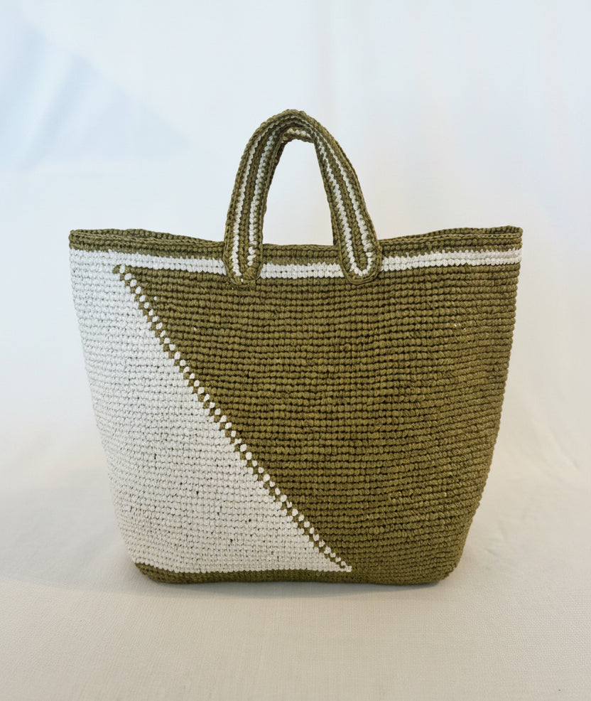 Woven bag with green and white pattern on a light background