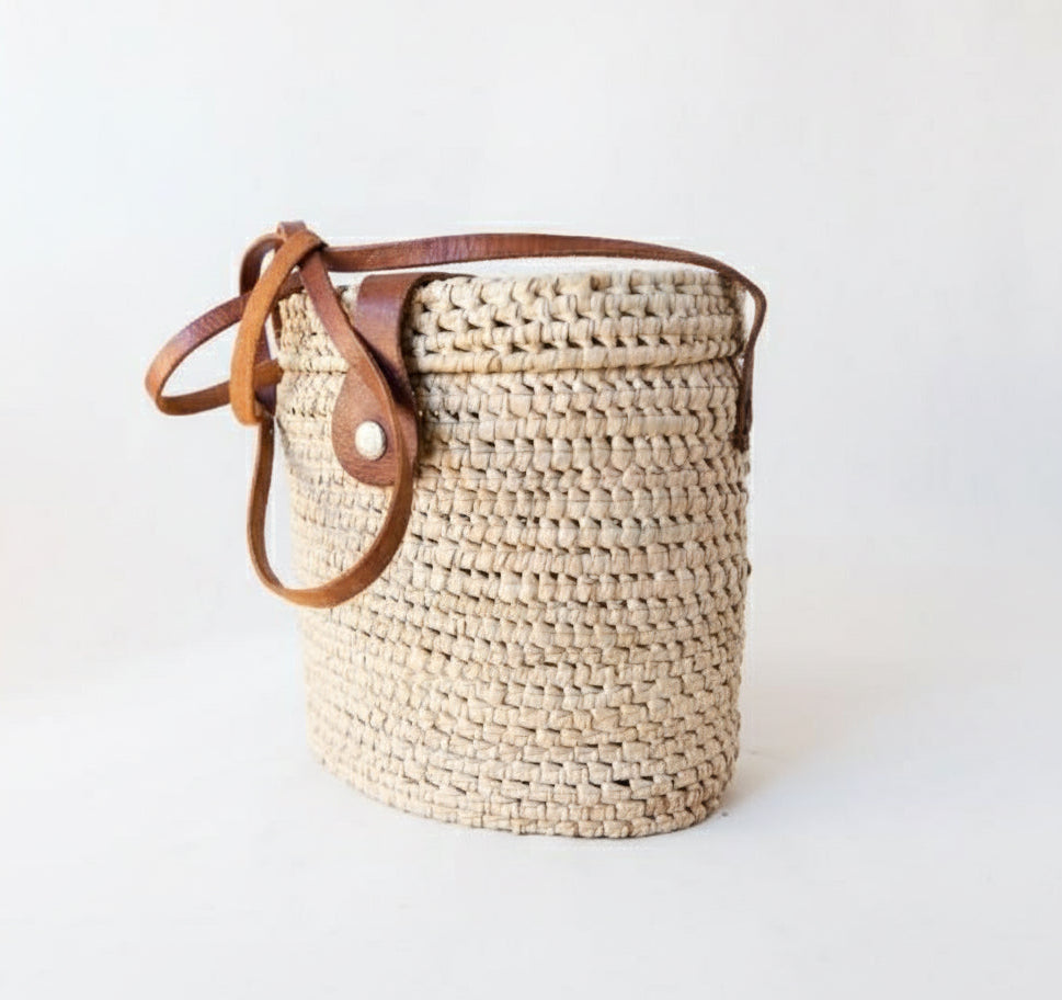 Product image of a natural woven rectangular bag with a leather strap and clasp 